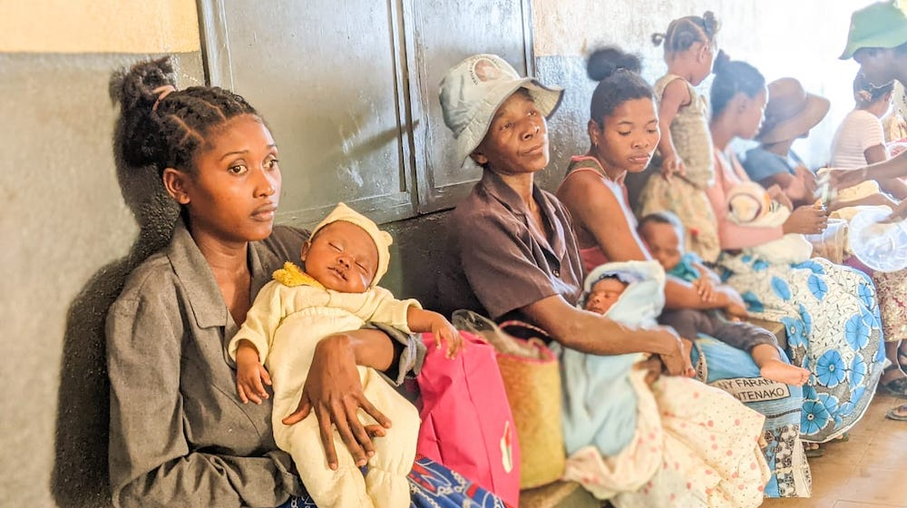 Georgette et son bébé, Freddy, attendent leur consultation au centre de santé de Maroalakely, où le personnel de l’UNFPA a également aidé la jeune femme à déclarer son enfant pour obtenir son certificat de naissance. © UNFPA Madagascar/Jean Martin
