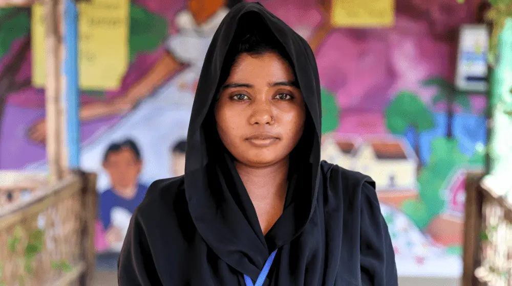 Portrait d’une jeune femme voilée portant des vêtements noirs.