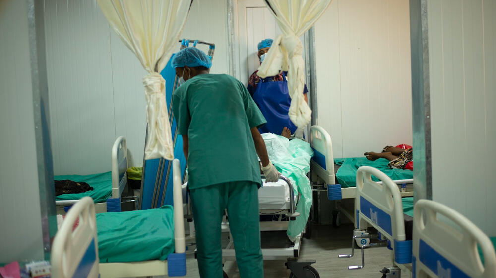  Des agents de santé poussent le brancard d’une patiente dans une maternité.